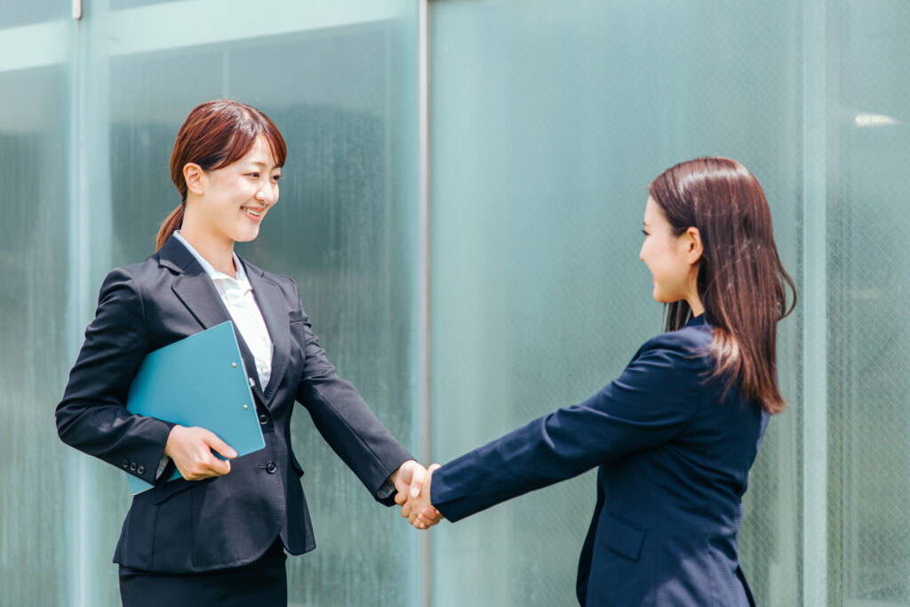 握手をするスーツ姿の女性