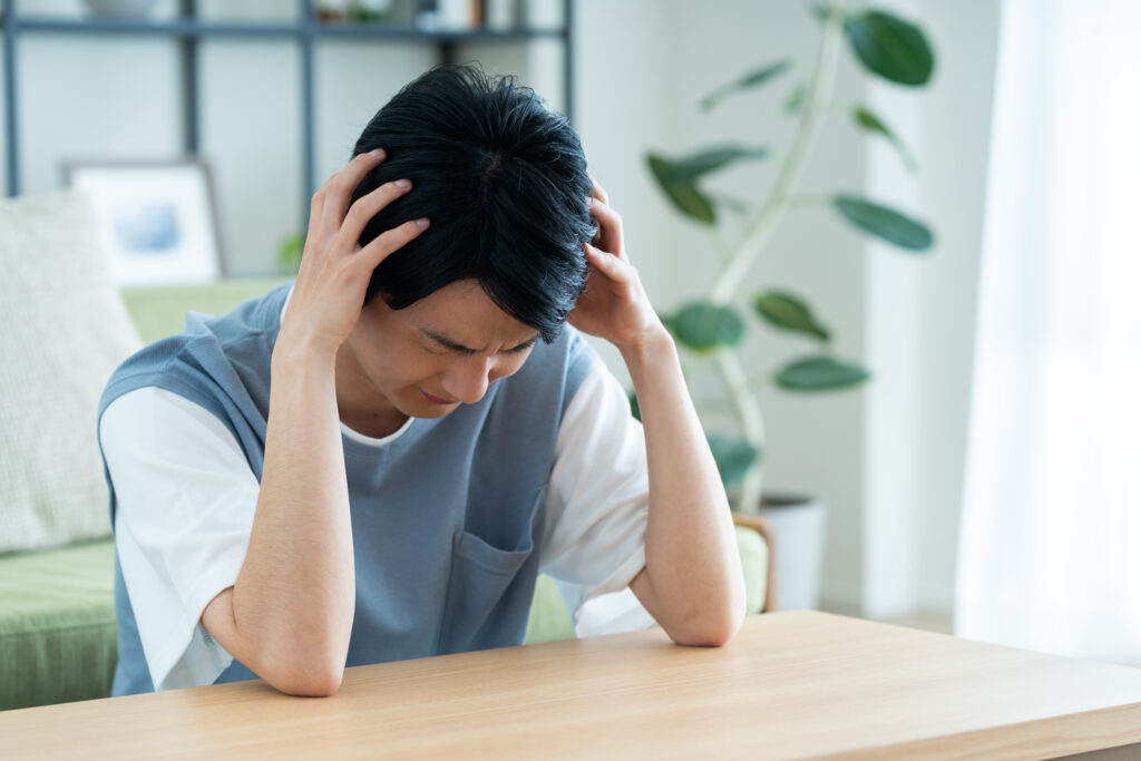 リビングで悩む男性
