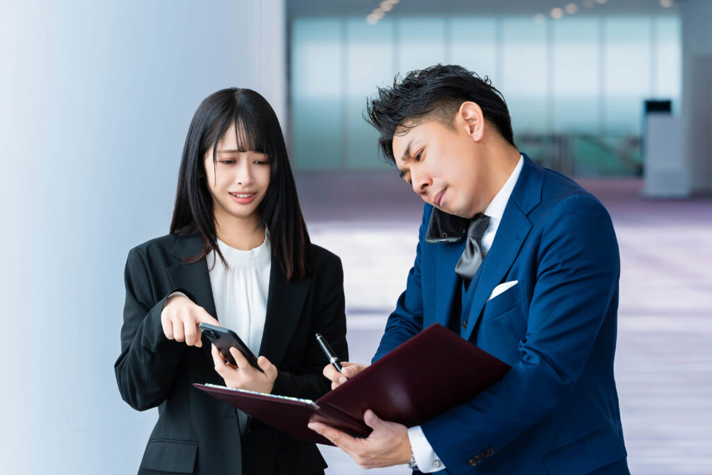 困った顔で携帯を指差す女性
