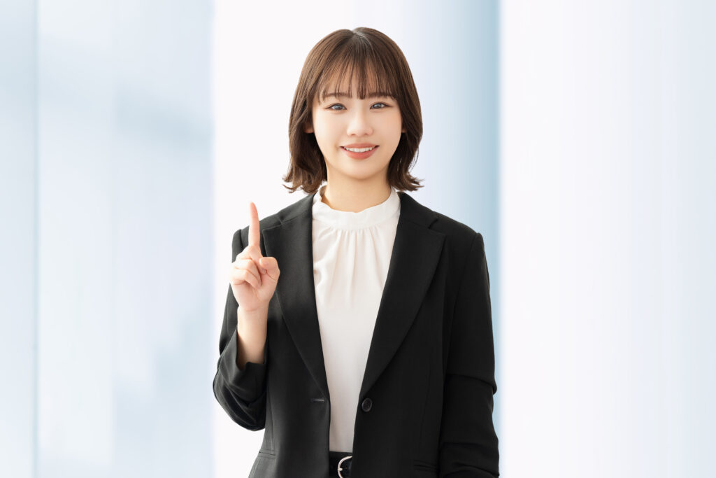 人差し指を立てて案内する笑顔の女性