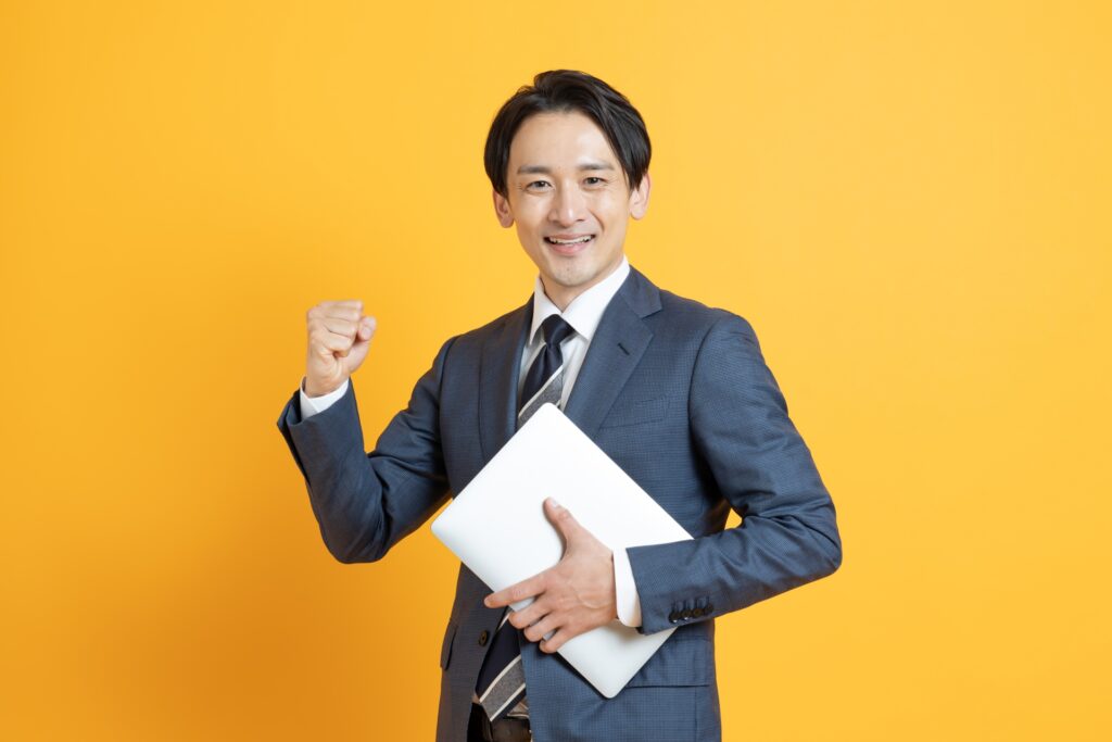 パソコン持つ笑顔のビジネスマン