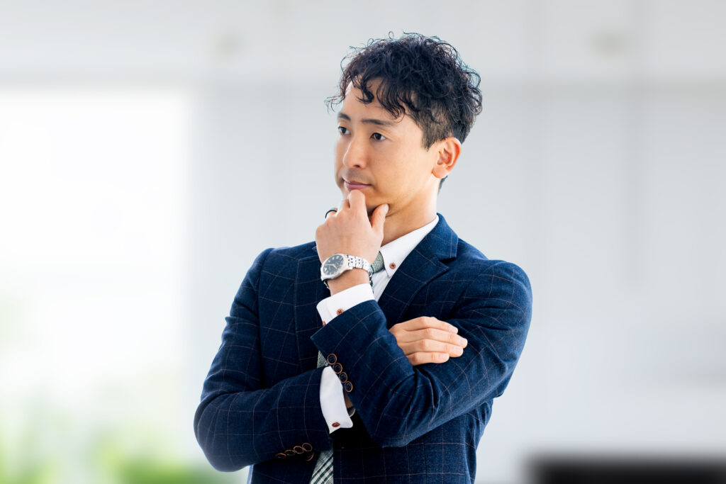 考えごとをする男性ビジネスマン