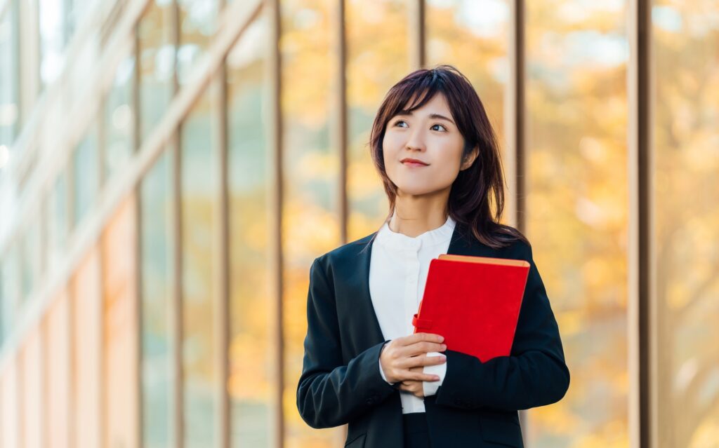 赤い手帳を持つ女性