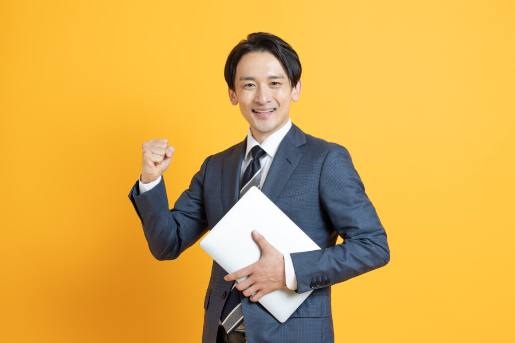 パソコン持つ笑顔のビジネスマン