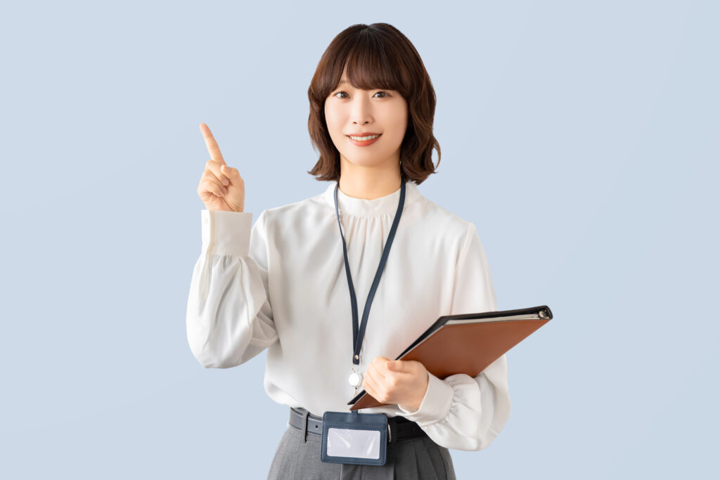 人差し指を立てて案内するビジネスウーマン