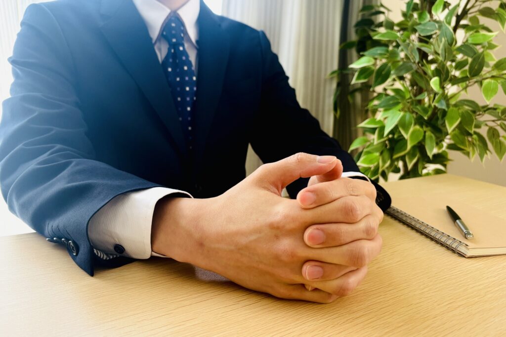 机に座り人の話を聞くビジネスマン