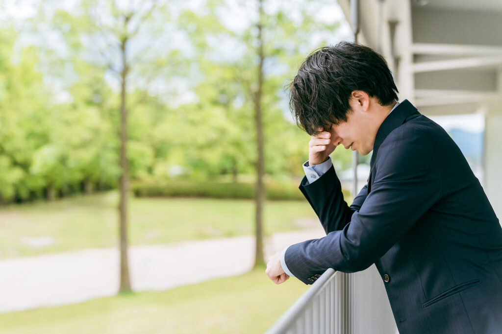 仕事で悩む若いアジア人ビジネスマン