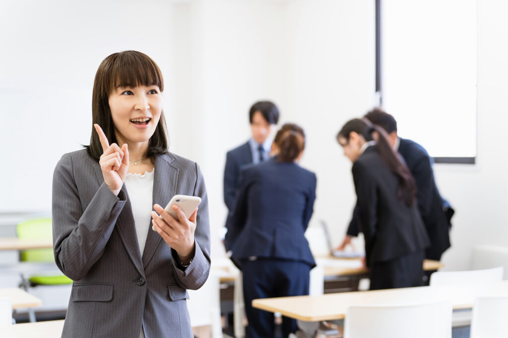 会議室でスマホを使うビジネスウーマン