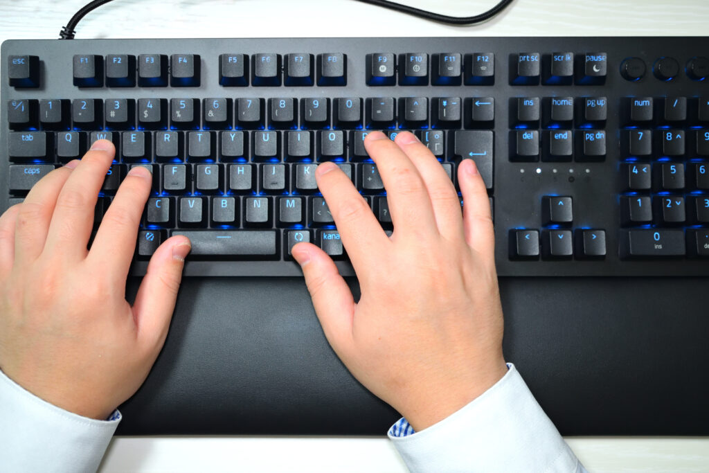 PCキーボードを操作する男性の手