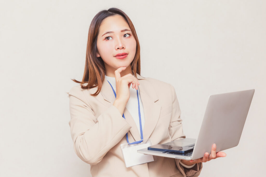 パソコンを持って考える女性