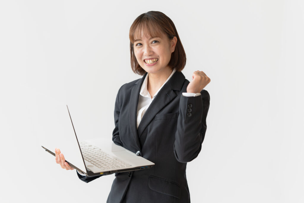 PCとガッツポーズする女性