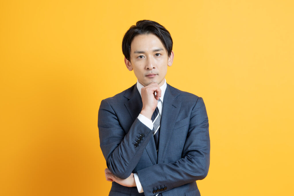 アゴに手を当てるビジネスマン