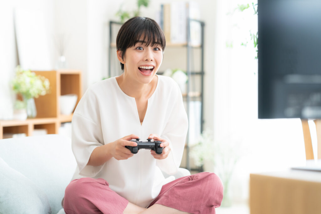 リビングでゲームをする若い女性
