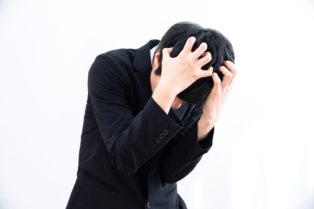 頭を抱えて悩み落ち込むビジネスマン