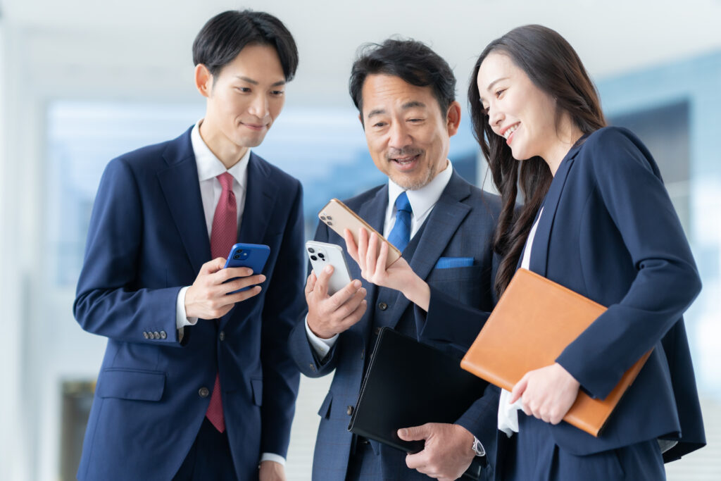 オフィスでスマホを見る男女のビジネスマン