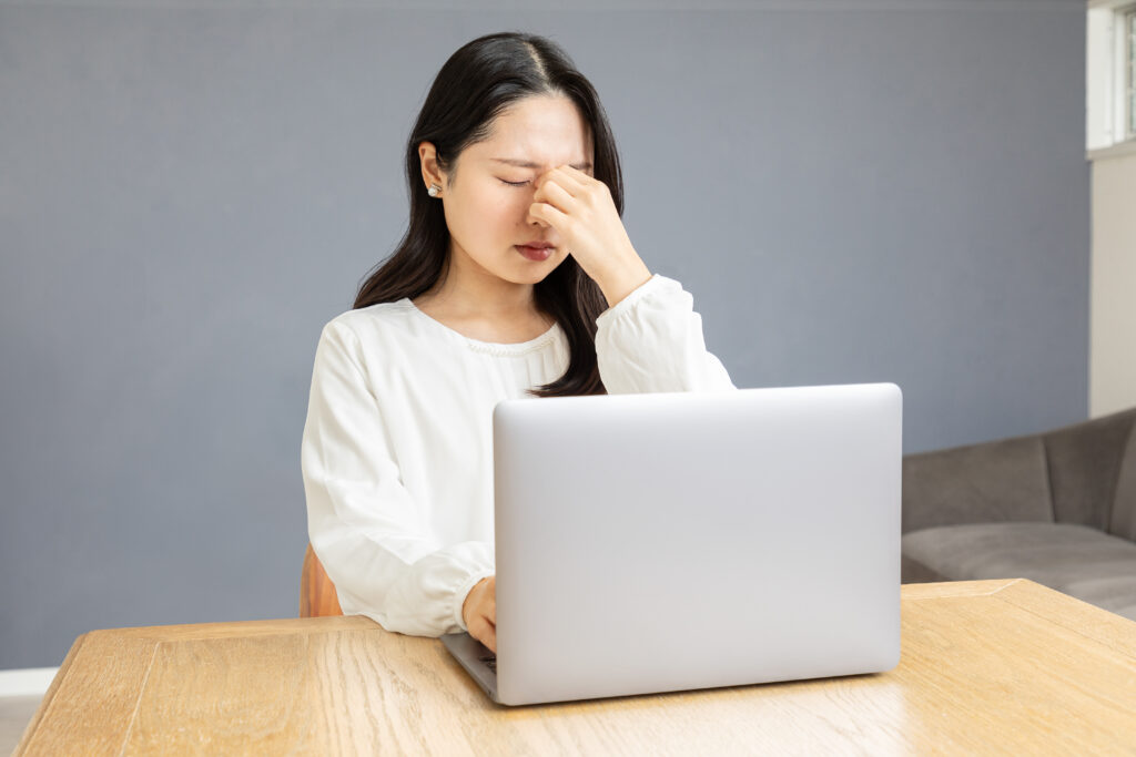 目の疲れを感じる女性