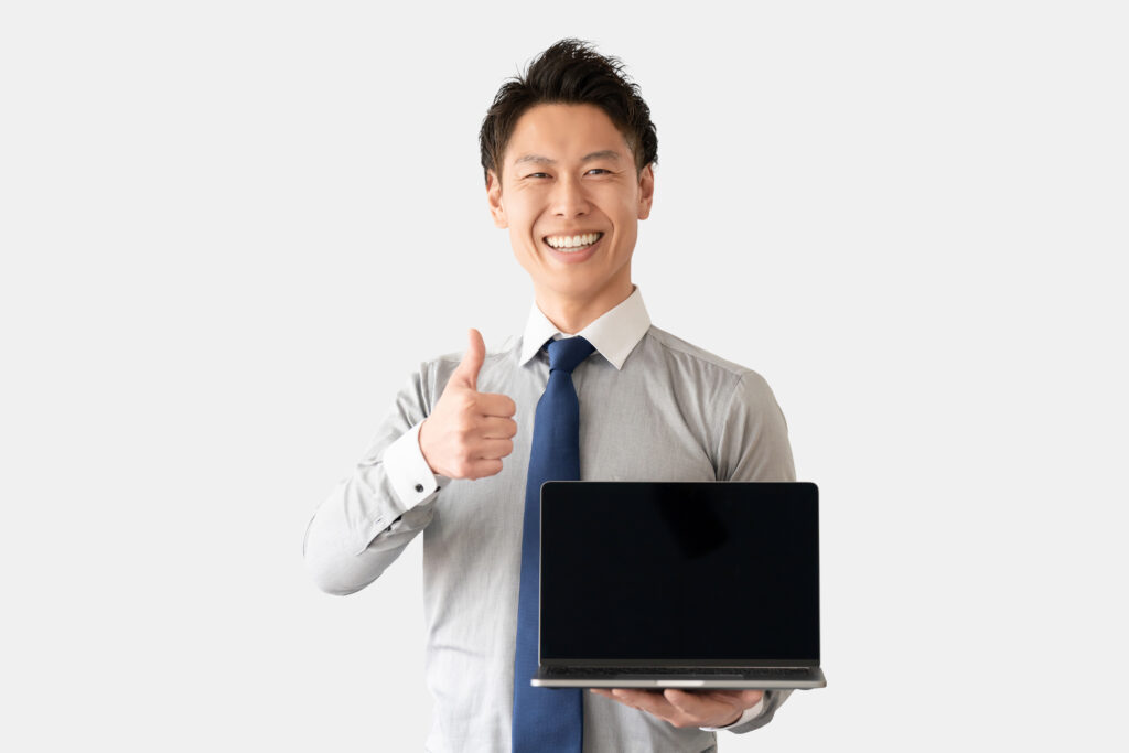 パソコンを持っていいねのポーズをする男性