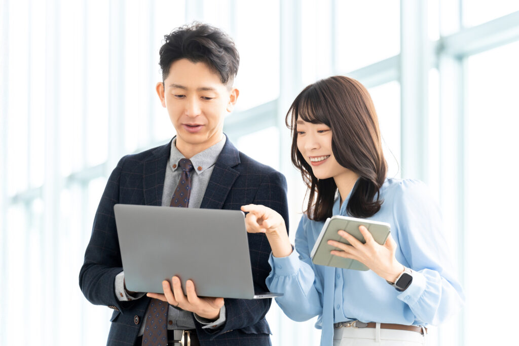 パソコンを見ながら話す男女ビジネスマン