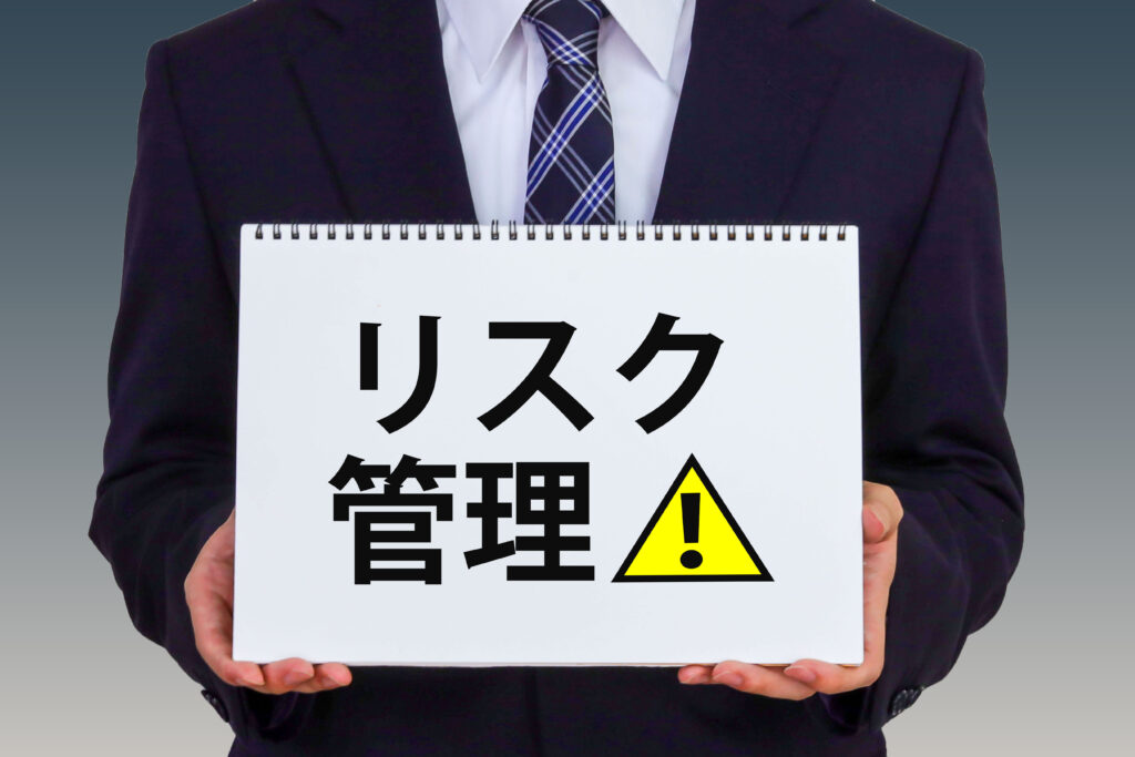 リスク管理のボードを掲げるビジネスマン