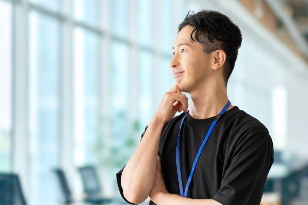 考えごとをする笑顔の男性ビジネスマン