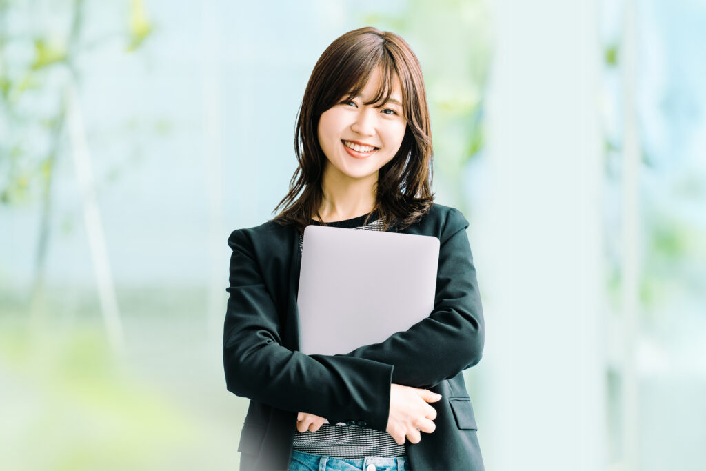 ノートパソコンを持つ笑顔の女性