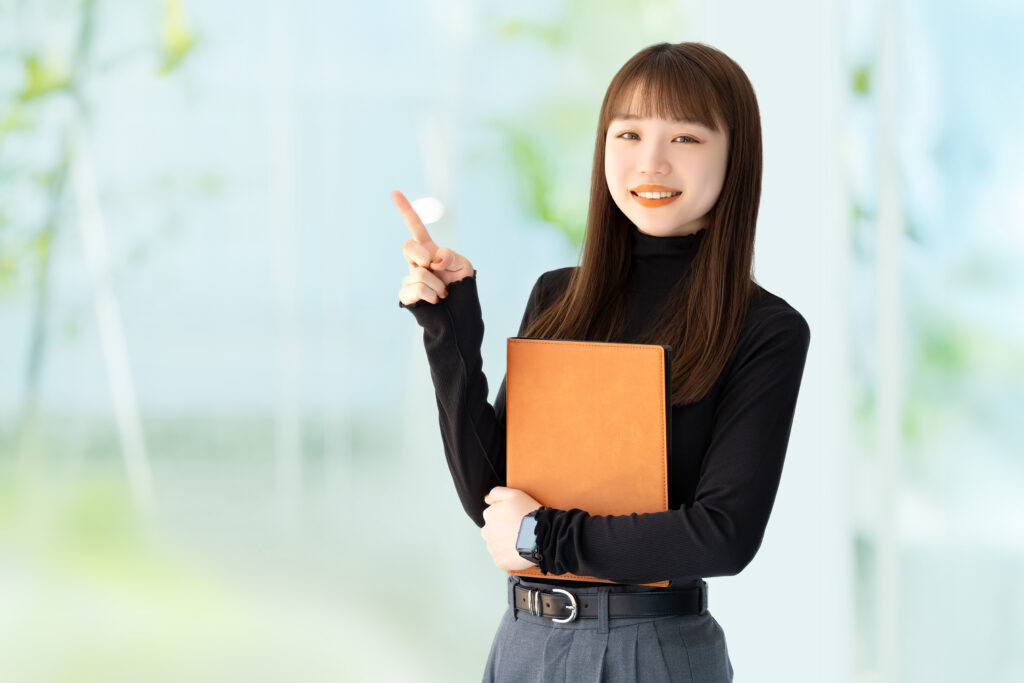 人差し指を立てて案内する笑顔の女性