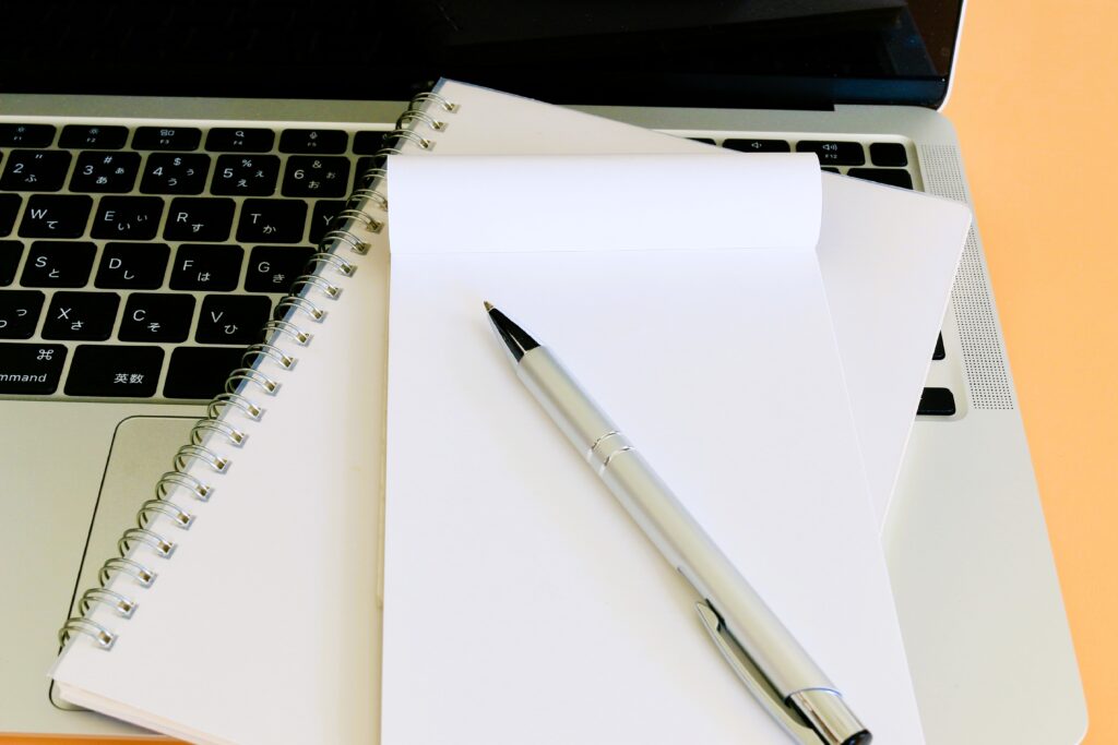 メモ帳とノートパソコン