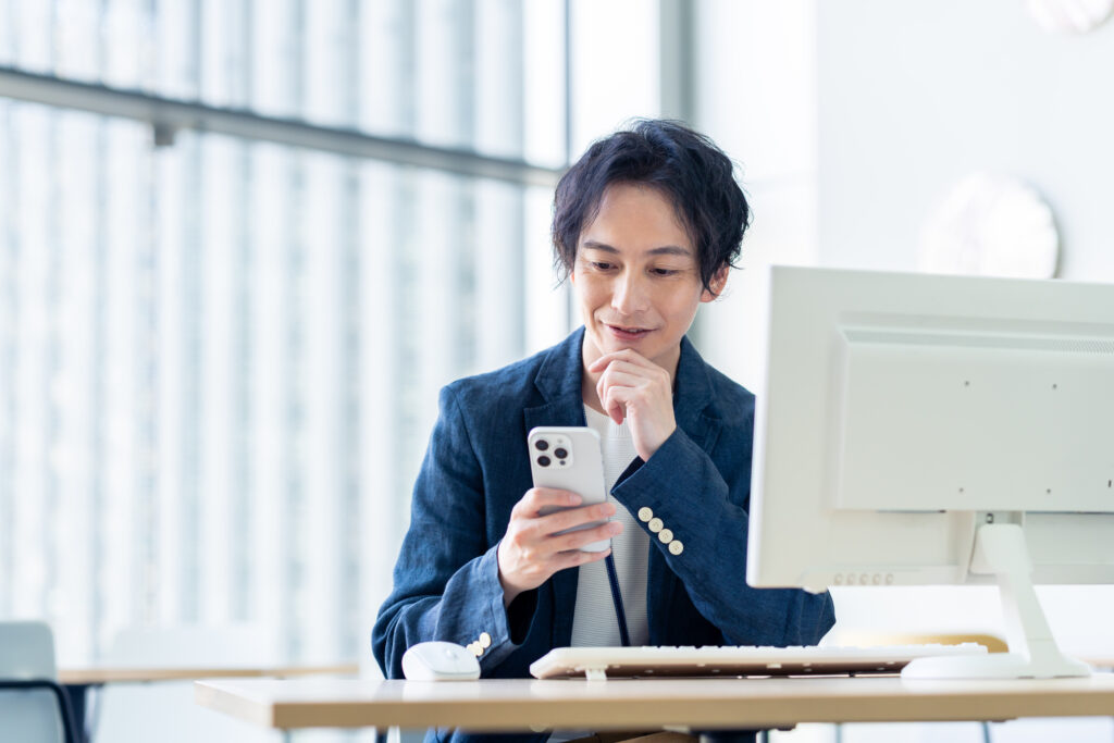 オフィスでスマホを見るビジネスマン