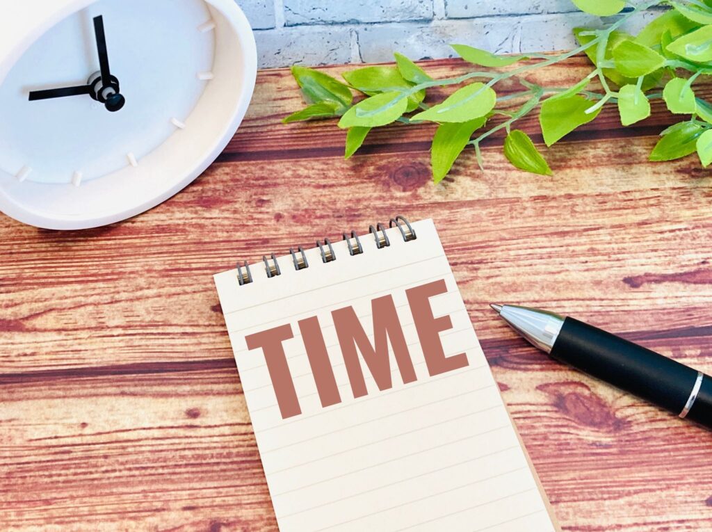 TIMEと書かれたメモ帳と時計