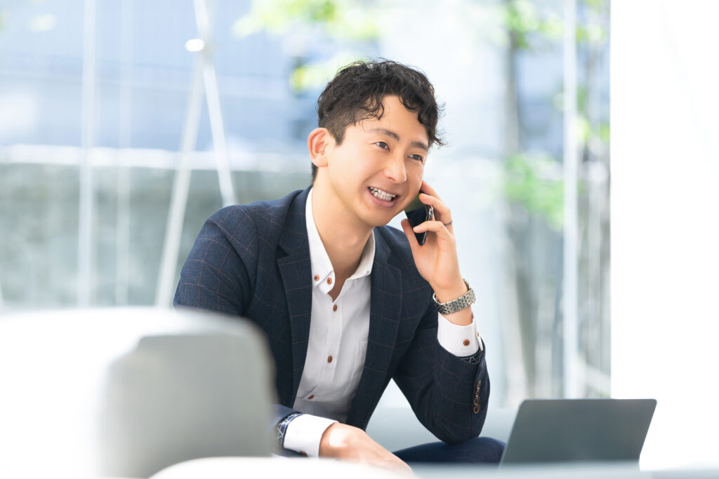スマホで通話をする笑顔の男性ビジネスマン