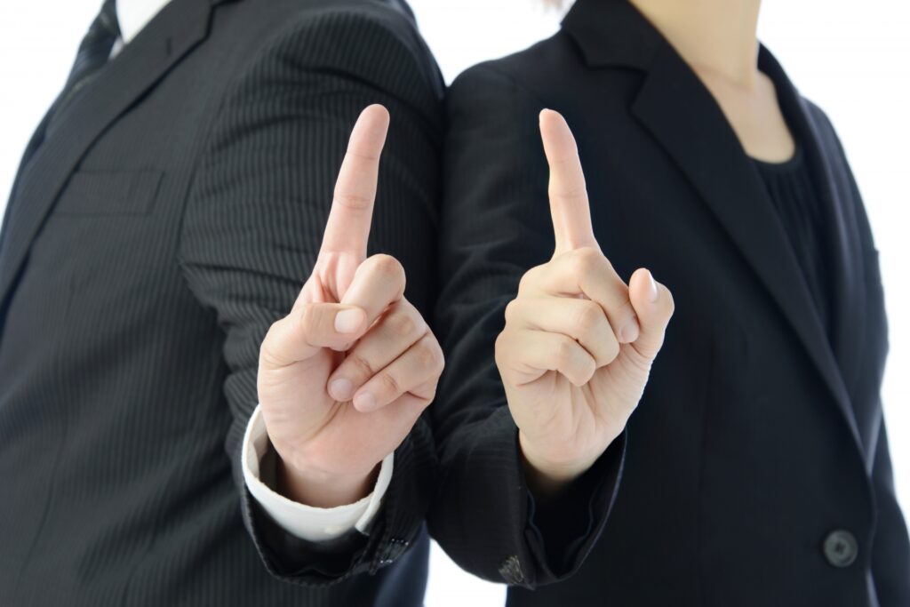 人差し指を立てるビジネスチーム