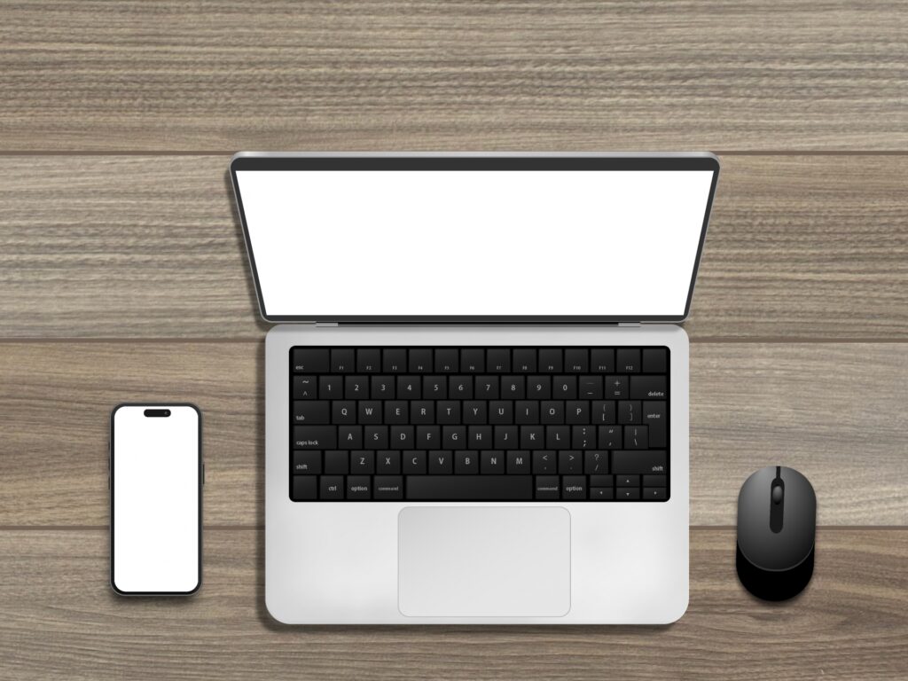 デスクの上のノートPCとスマートフォン