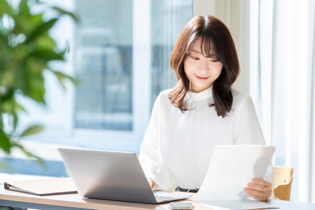 デスクワークをする笑顔のビジネスウーマン