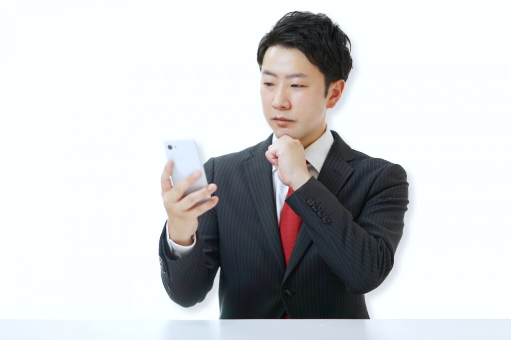 スマホを眺めるビジネスマン