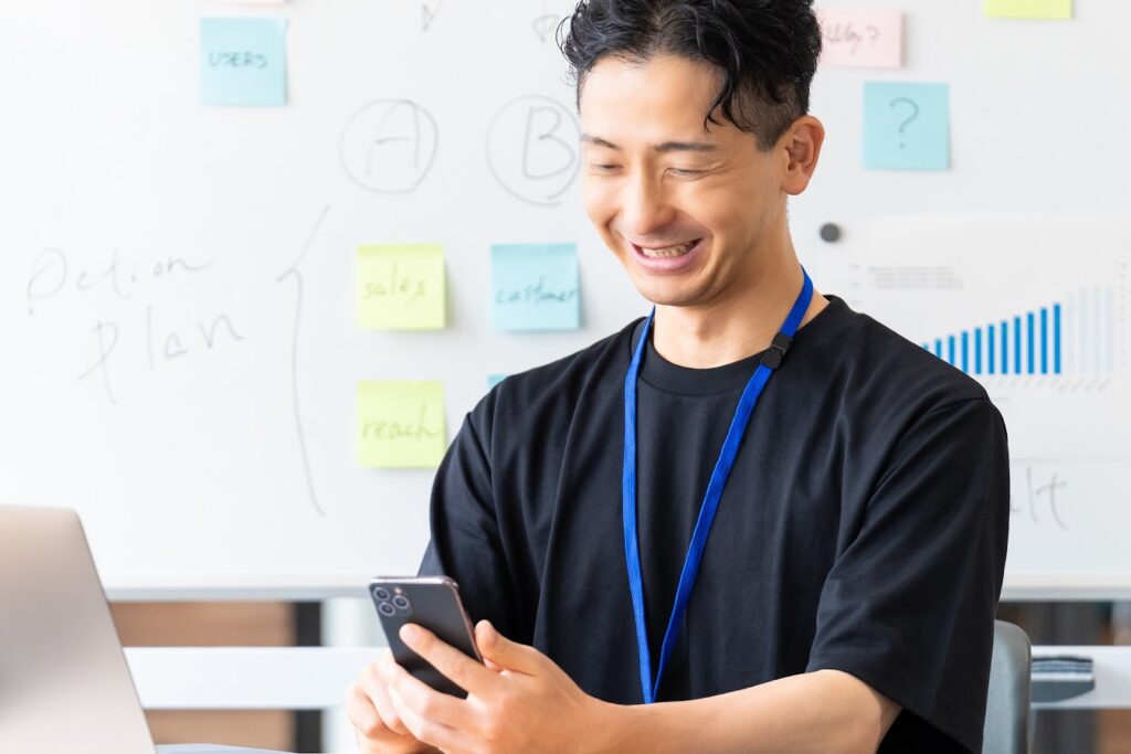 スマホを見て喜ぶ男性