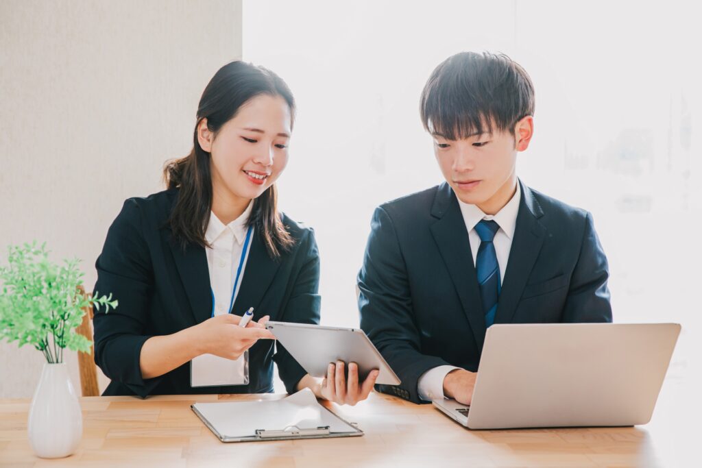 スーツを着た男女が働くシーン