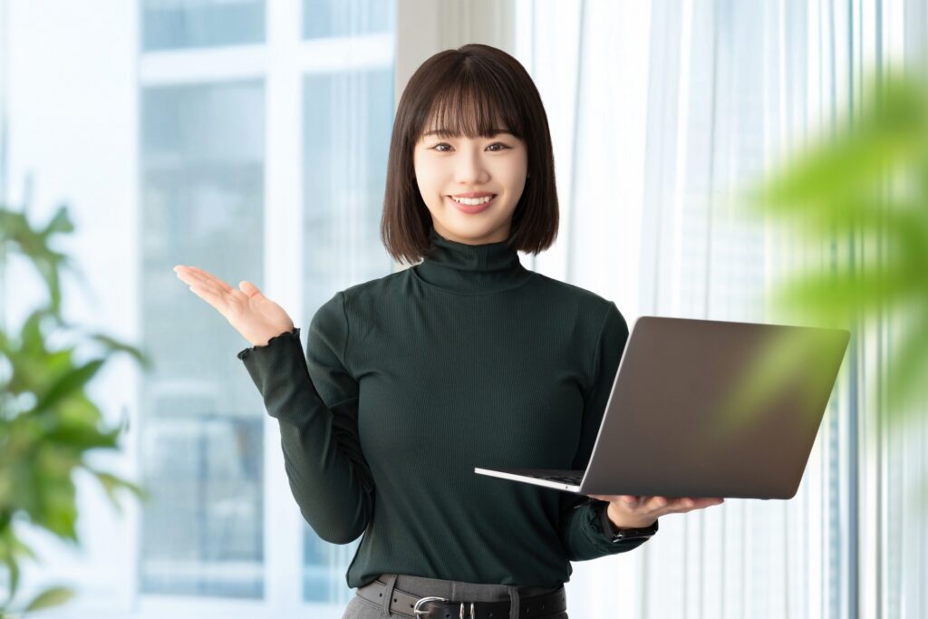 ノートパソコンを手に載せる女性