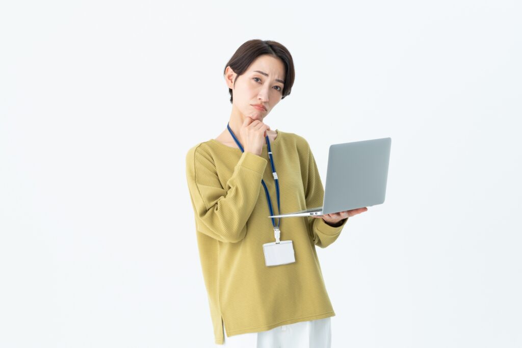 ノートパソコンを持つ困り顔の女性