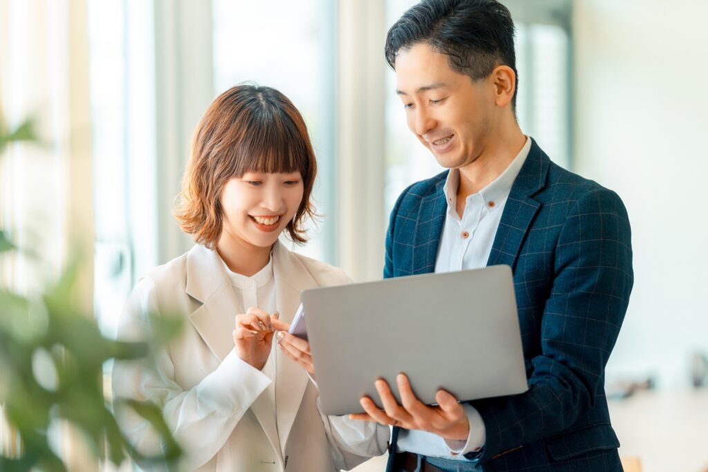 パソコンとスマホを出す男女