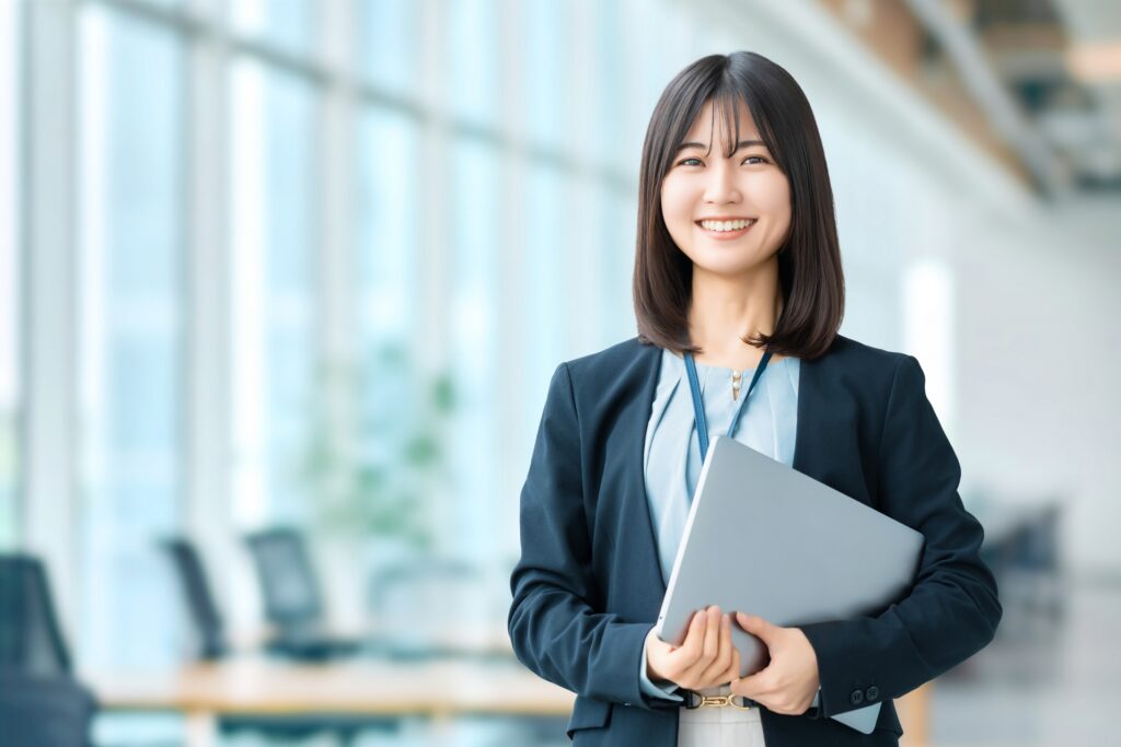 パソコンを持って微笑む女性