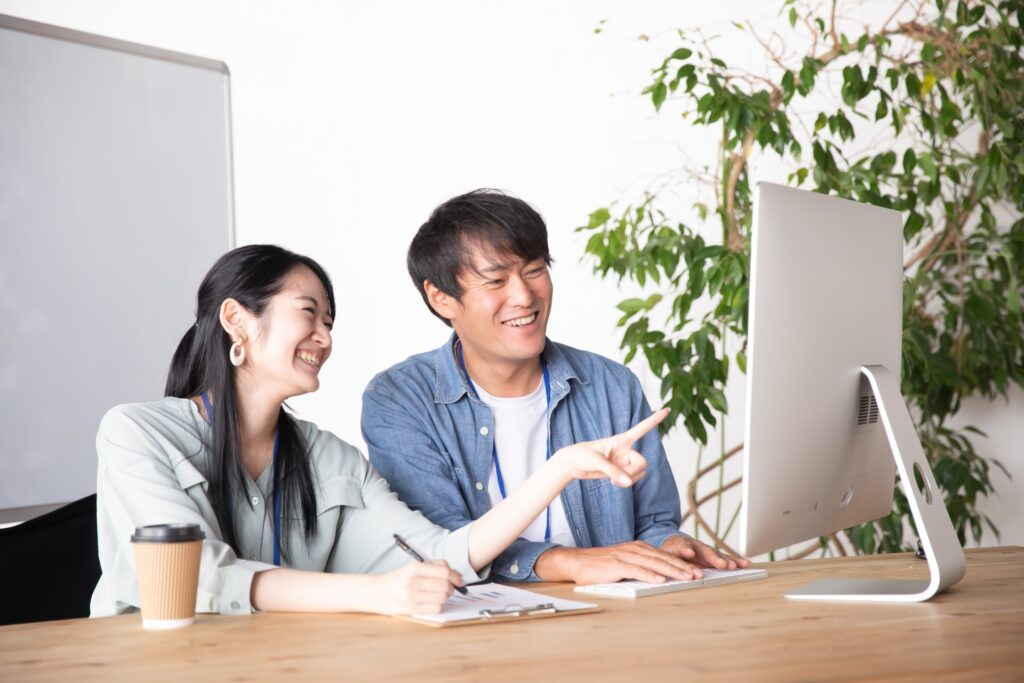 パソコンを見る楽しそうな男女