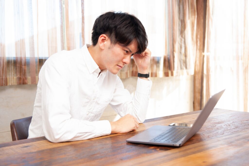 パソコン画面を見る男性