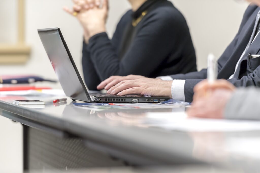 ノートパソコンで記録を取る男性