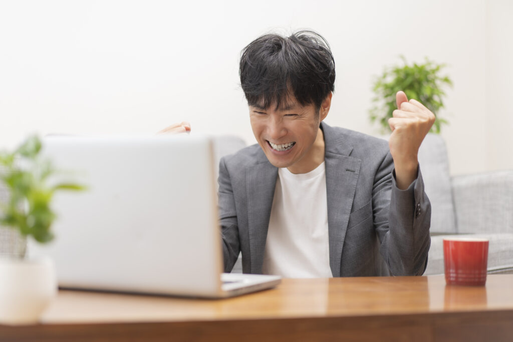 喜ぶ男性とパソコン