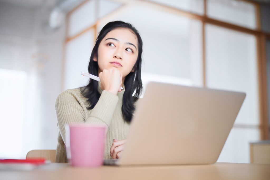 パソコンの前で悩む女性