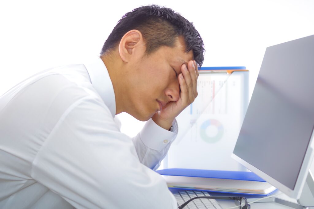 デスク仕事に疲れた男性