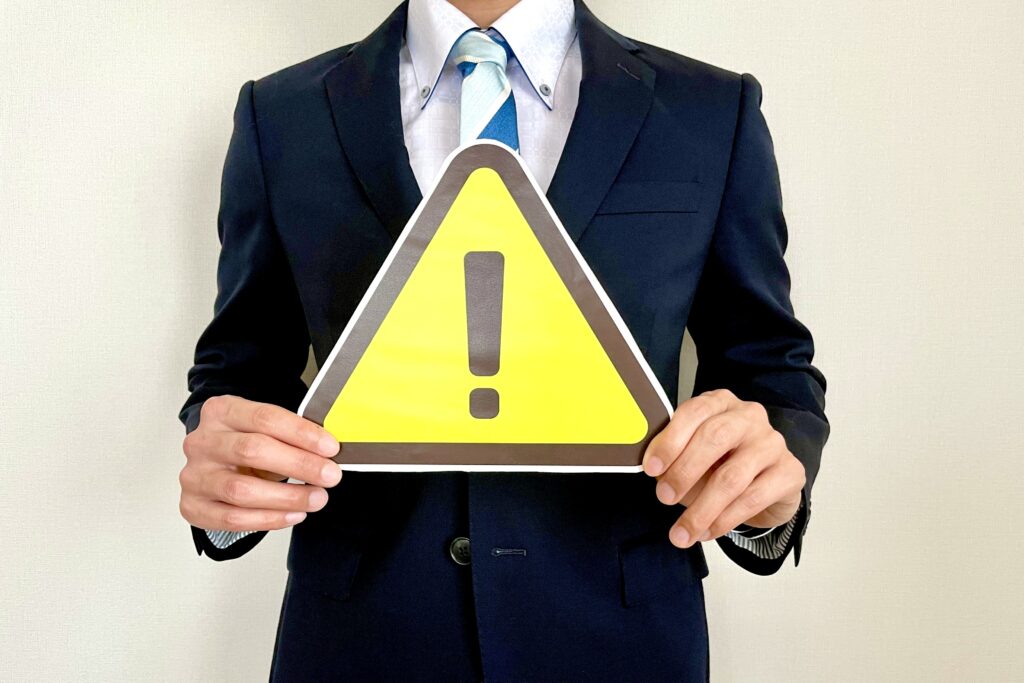 注意マークを正面に持つサラリーマン
