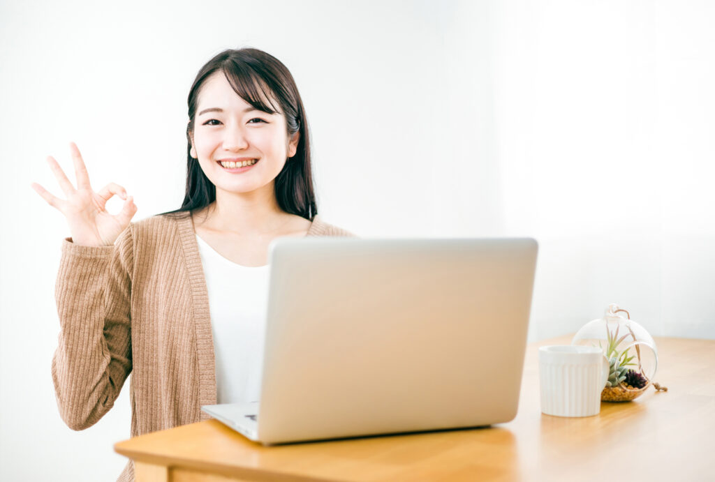 家でノートパソコンを使う女性