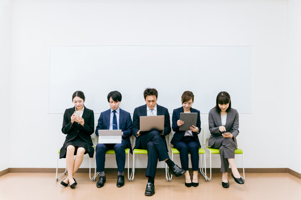 会社でガジェットを使うスーツ姿の会社員