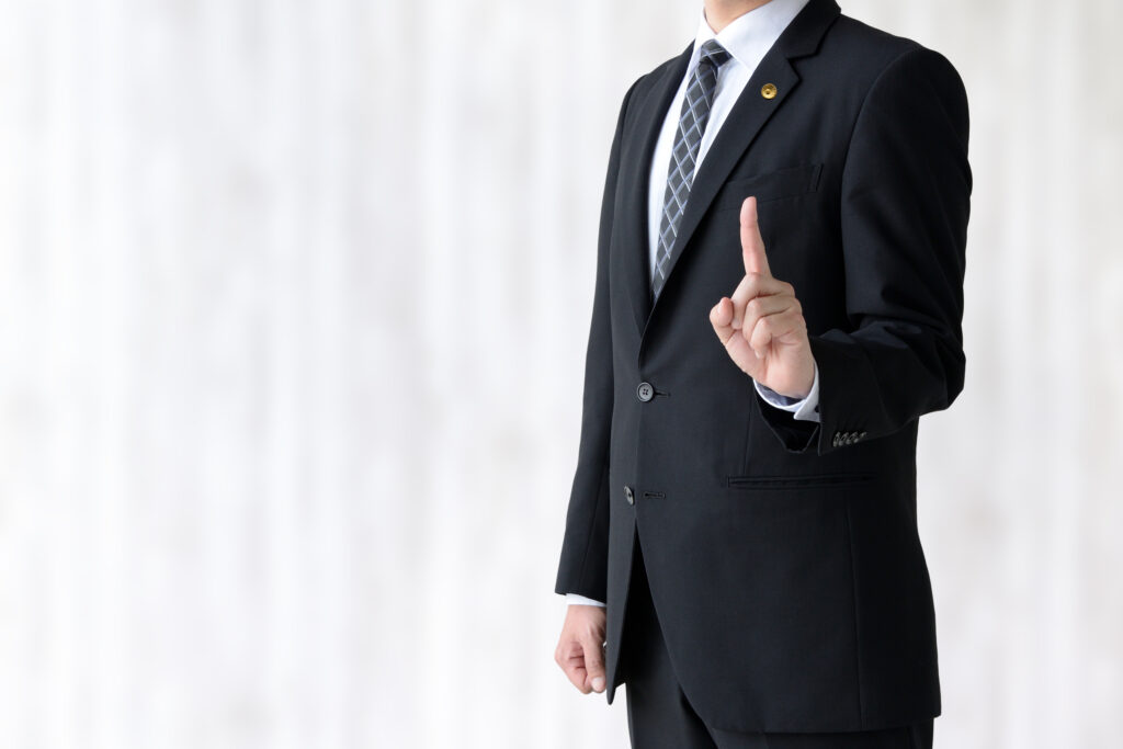 人差し指を立てる男性弁護士